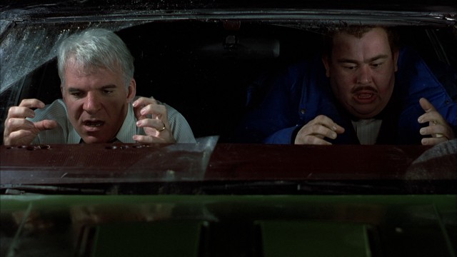 Neal Page (Steve Martin) and Del Griffith (John Candy) pull their fingernails out from the dashboard after a very close call in their rented car.