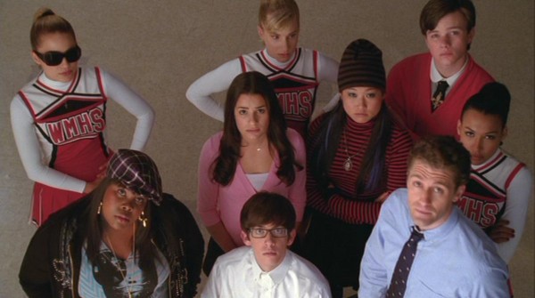 Quinn (Dianna Agron), Brittany (Heather Morris), Kurt (Chris Colfer), Rachel (Lea Michele), Tina (Jenna Ushkowitz), Santana (Naya Rivera), Mercedes (Amber Riley), Artie (Kevin McHale), and Will (Matthew Morrison) all stare anxiously at the clock, waiting to see if any of the football players will show up for glee club rehearsal.