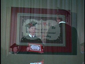 Hank awards Dean Jones his diploma in a brief flashback scene in "The Million Dollar Duck" (1971).